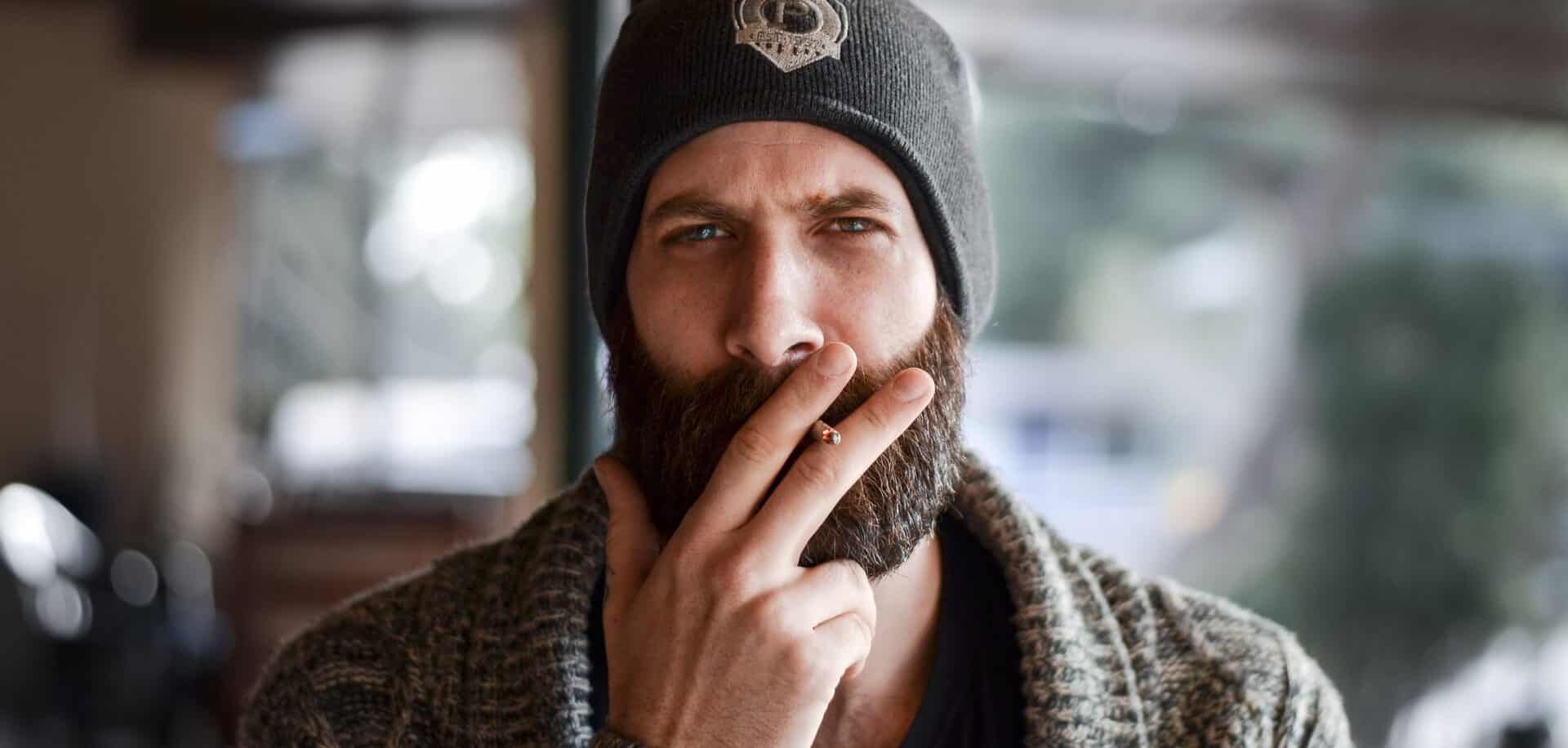 Hipster mit Bart und Zigarette