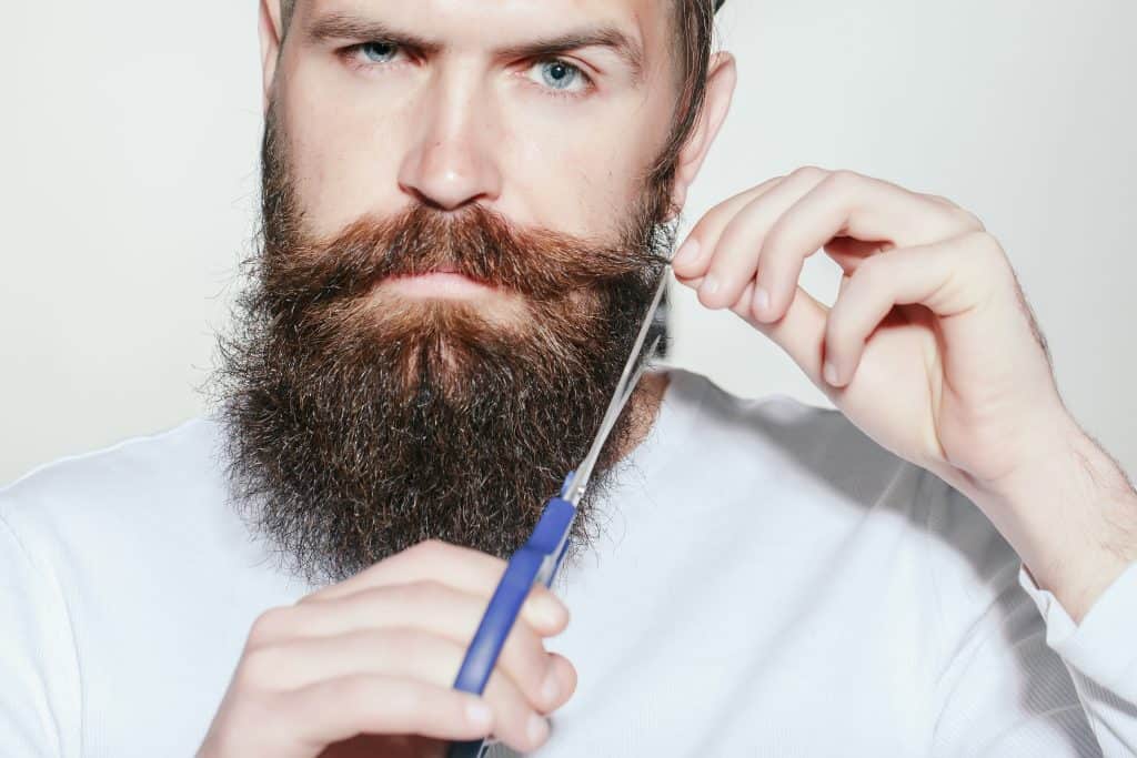 Man cuts beard with scissors