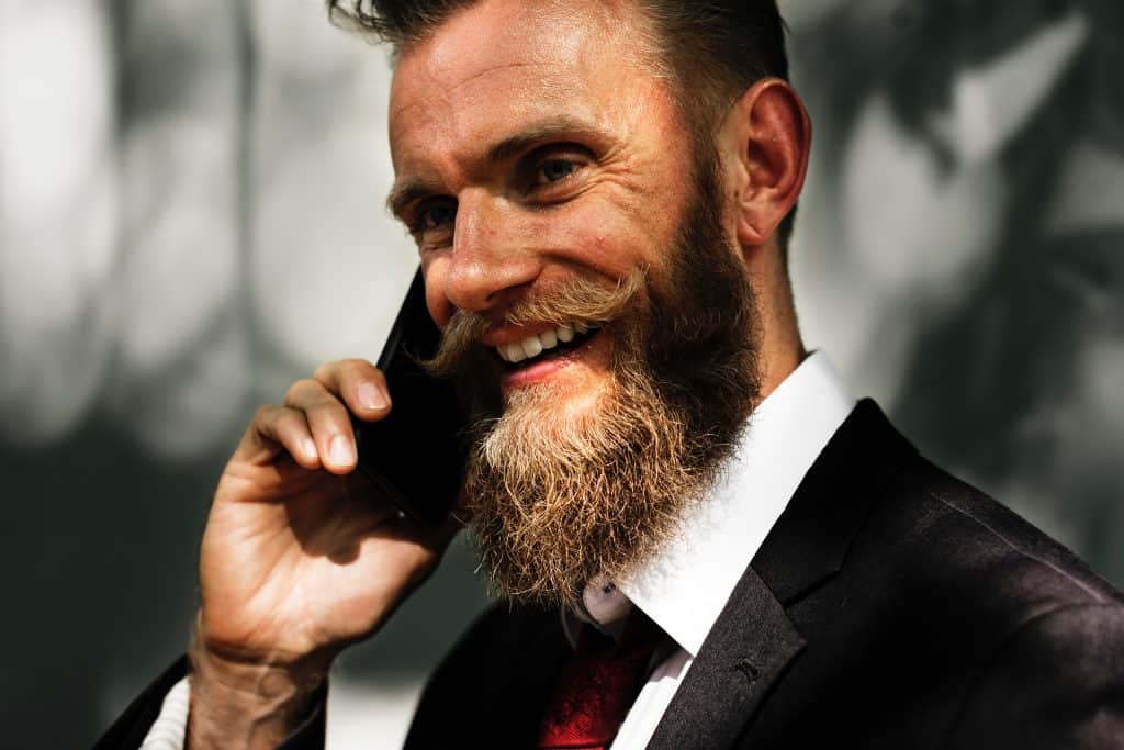 Mann mit gezwirbelten Bart telefoniert